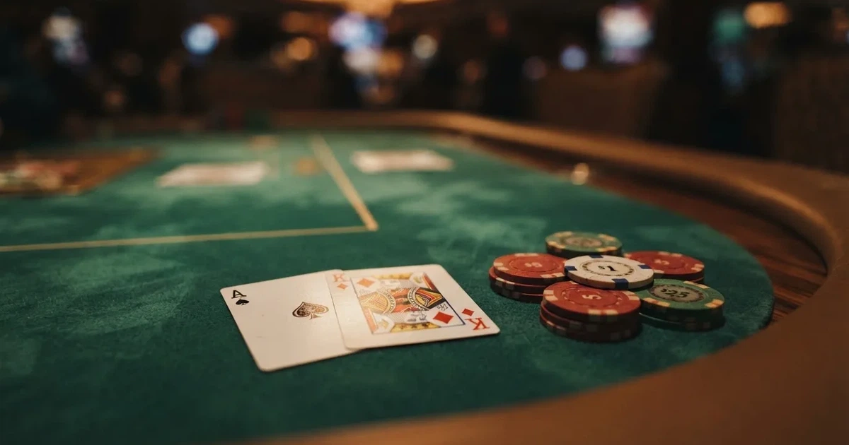 A close-up of a green felt gaming table with cards and chips mid-hand.